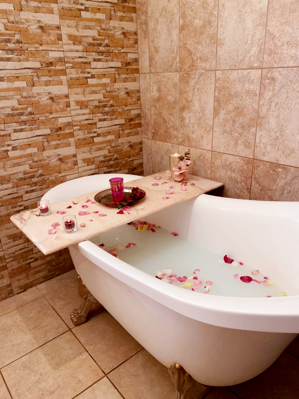 EVE spa bath room with claw-foot tub and rose petals